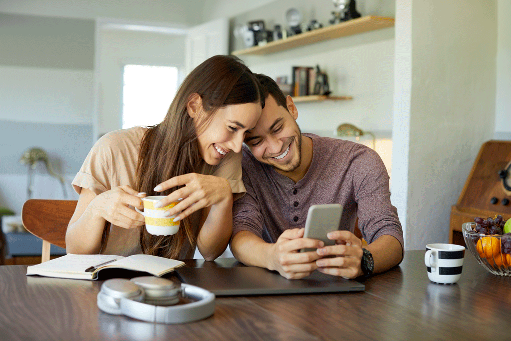 couple sitting in the comfort of their home looking at phone | air conditioning installation phoenix az scottsdale az 