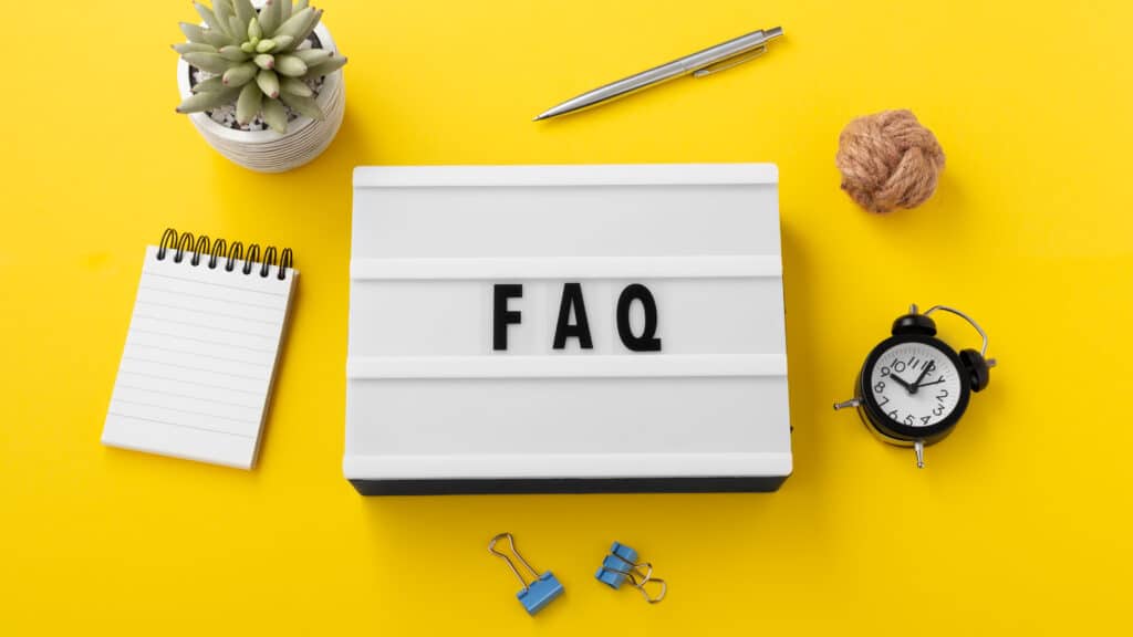 FAQ word on lightbox with office supplies on yellow background, FAQs for AC Repair in Sedona
